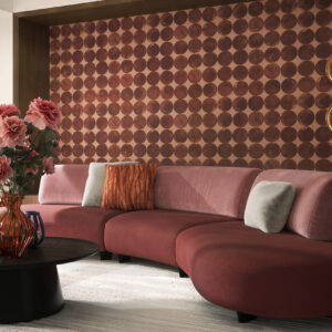 Elegant pink sectional sofa with plush cushions, set against a patterned accent wall, perfect for contemporary living rooms.