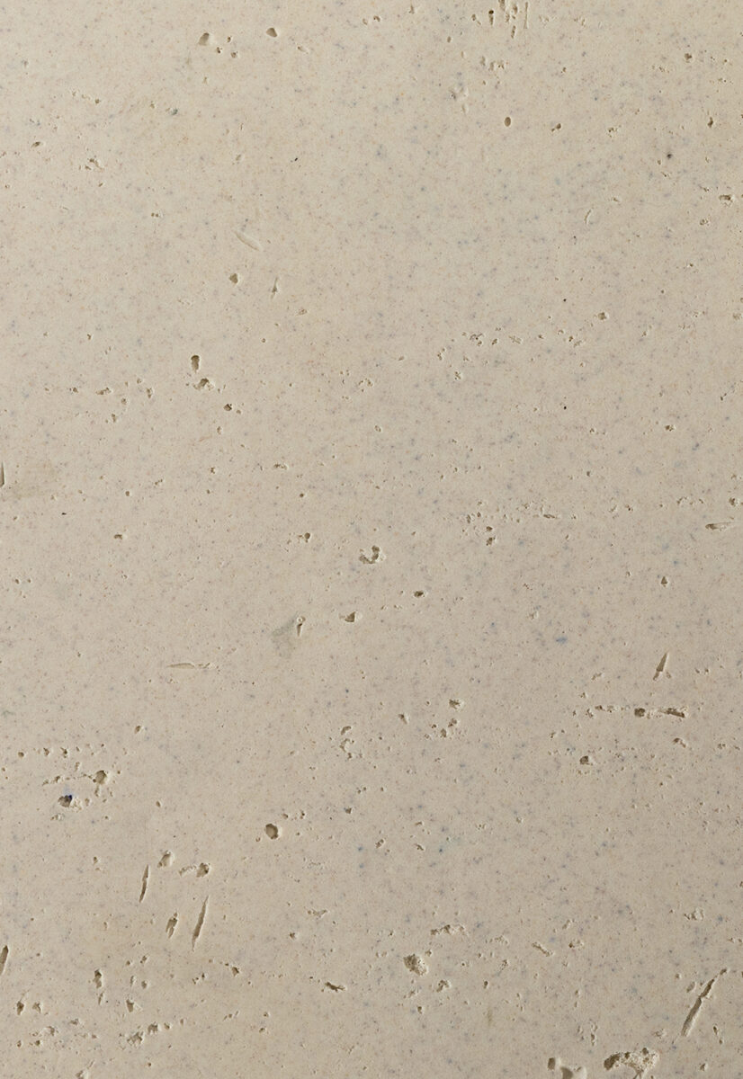 Light beige textured wall with small holes and imperfections, ideal for interior decor or background use. Perfect for showcasing furniture or creating a neutral aesthetic.