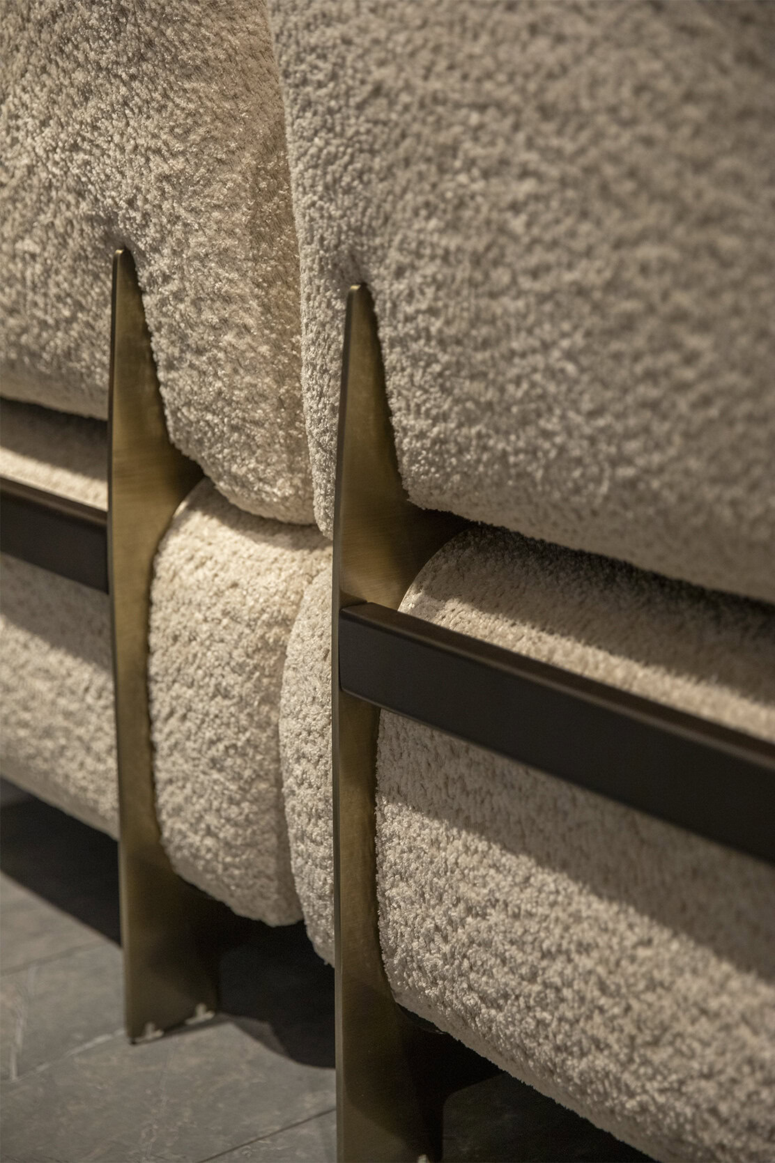 Mobilier luxos, tapițat cu catifea texturată bej, cu accente elegante din alamă și metal negru, îmbinând eleganța modernă cu confortul luxos într-un decor contemporan.