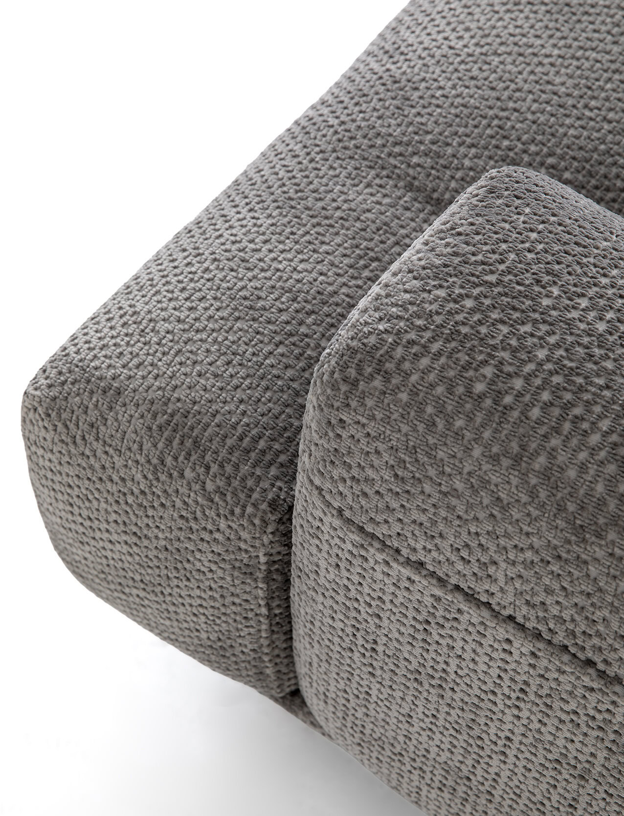 Prim-plan al unei canapele de colț moderne din material textil gri, cu tapițerie texturată și perne moi pentru o ședere confortabilă.