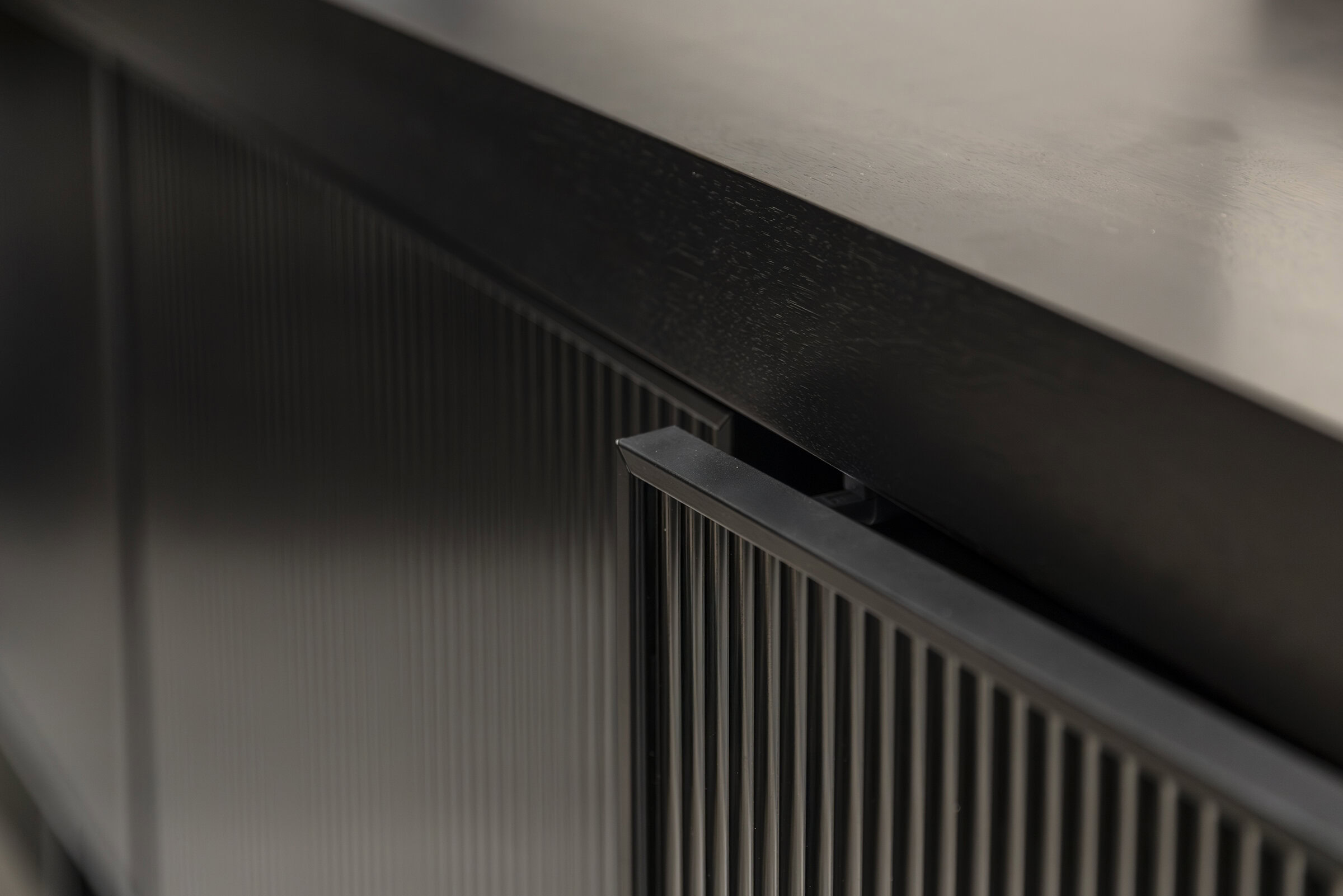 Mobilier modern, negru, elegant, cu design cu lamele verticale, care pune accent pe stilul contemporan și măiestria de înaltă calitate pentru interioare elegante de casă sau birou.