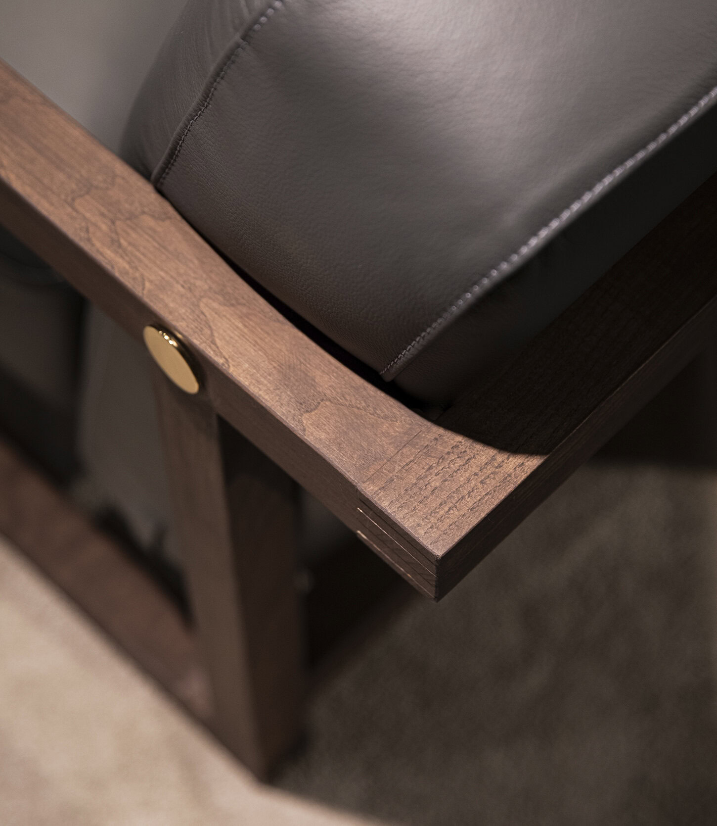Colț de mobilier din lemn maro neted, cu pernă din piele închisă la culoare, pentru decor modern de dormitor sau living.