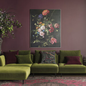 Stylish green sofa with plush cushions in a modern living room setting, complemented by vibrant floral artwork and lush indoor plants for a cozy, contemporary ambiance.