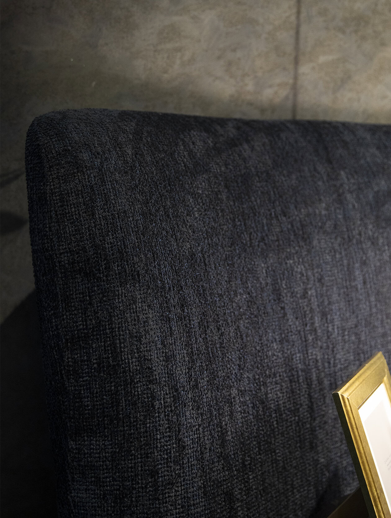Luxurious dark gray upholstered sofa with textured fabric, perfect for modern living rooms, providing comfort and elegant style.