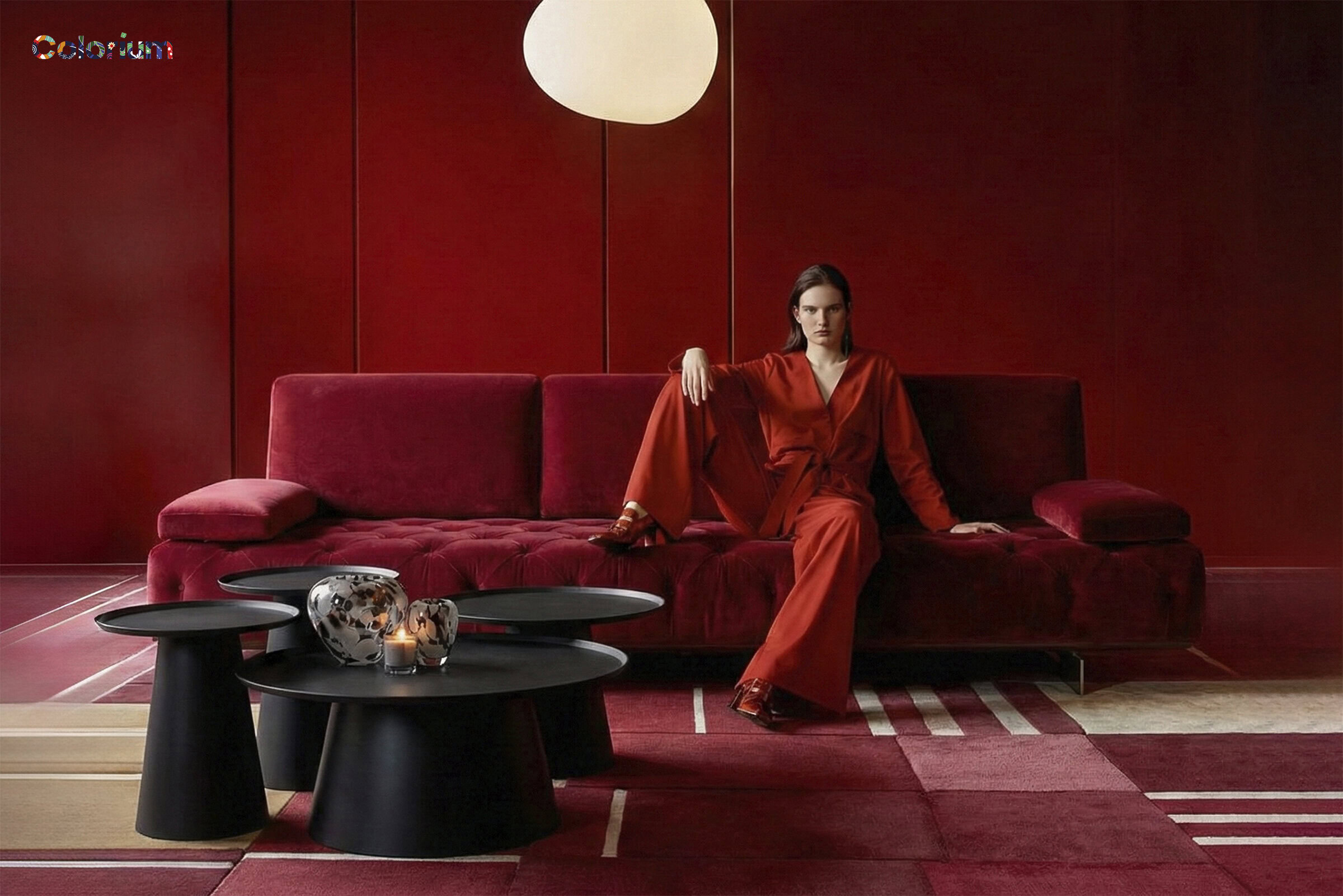 Elegant modern living room featuring a deep red sofa, matching red walls, and stylish black coffee tables, creating a luxurious and contemporary ambiance.