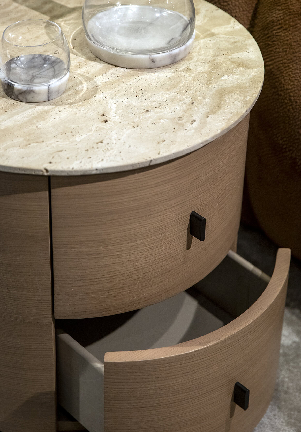 Polished beige marble top side table with minimalist drawers and black handle details, showcasing elegant modern furniture design.