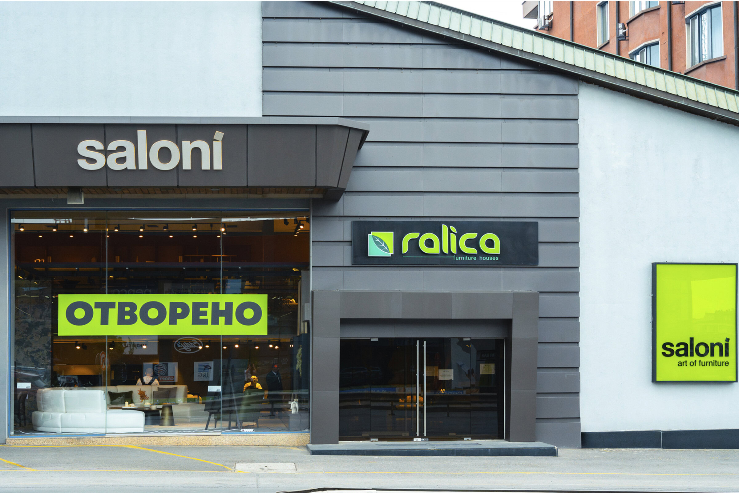 Modern furniture store facade with "Saloni Furniture" signage and large green "ОТВОРЕНО" (Open) sign, showcasing contemporary home furnishings and interior design options.